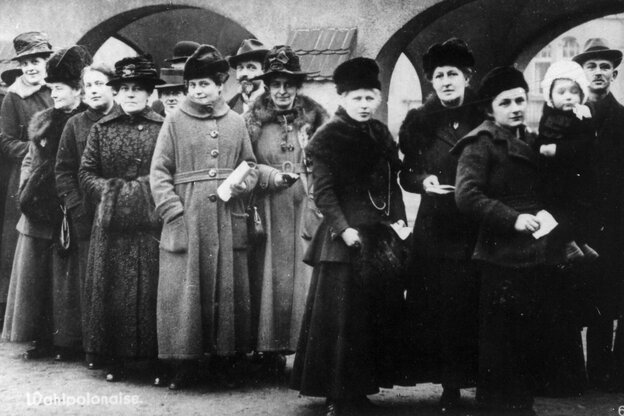 Eine Schwarz-Weiß-Fotografie zeigt mehrere Frauen, die in einer Reihe hintereinander stehen Eine Schwarz-Weiß-Fotografie zeigt mehrere Frauen, die in einer Reihe hintereinander stehen