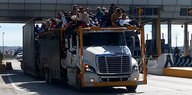 Migranten aus Mittelamerika fahren auf einem LKW durch eine Mautstation in Mexiko