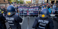 Polizisten stehen vor einer Gruppe von Menschen, die gegen Nazis demonstrieren