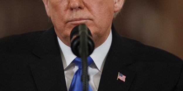 Trumps Unterseite des Gesichts vor einem Mikro