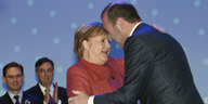 Angela Merkel und Manfred Weber liegen sich in den Armen