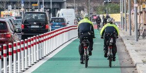 eine Fahrrad-Streife der Polizei fährt auf den ersten mit Pollern geschützten Radweg an der Holzmarktstraße