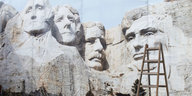Plakatwand mit Mount-Rushmoremotiv und eine Leiter