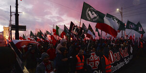 Menschen auf einer Demonstration, u.a. polnische Flaggen werden geschwungen