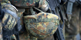 Ein Bundeswehrhelm und eine Waffe