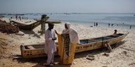 Eine Frau und ein Mann sprechen am Strand von Dakar miteinander