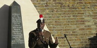 Schwarzer Veteran spricht vor Denkmal
