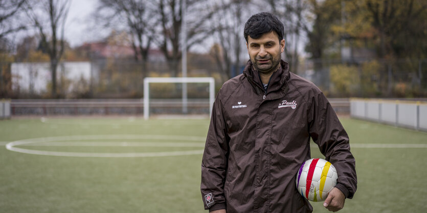 Serdal Celebi steht auf einem Fußballplatz.