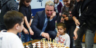 Ein Mann spielt mit Kindern Schach