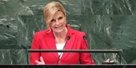 Die kroatische Präsidenten steht an einem Rednerpult der UN, vor grünem Hintergrund