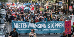 Demonstranten vor einem Transparent „Mietenwahnsinn stoppen“