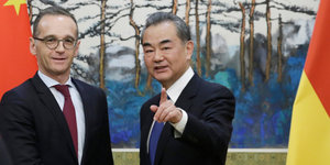 Heiko Maas und sein Kollege Wang Yi stehen nebeneinander
