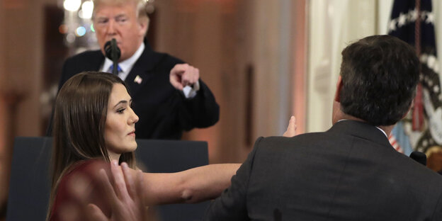 Trump zeigt mit dem Finger auf einen Mann, der nur von hinten zu sehen ist