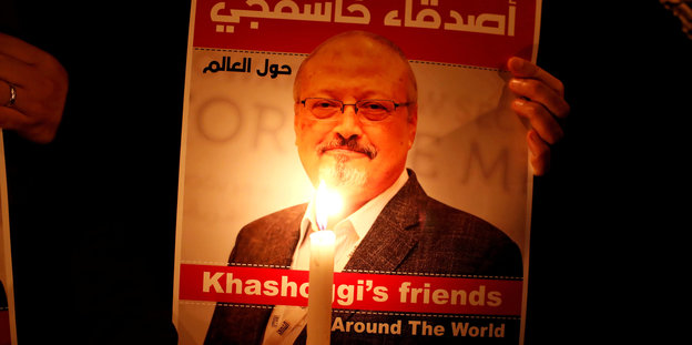 Ein Demonstrant hält vor einem Bild von Khashoggi eine Kerze