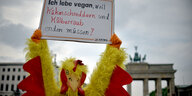 Ein Demonstrant hält am 13.05.2017 in Berlin bei einer Vegan-Demonstration vor dem Brandenburger Tor ein Schild mit der Aufschrift " Ich lebe vegan weil Kükenschreddern und Kälberraub enden müssen!"