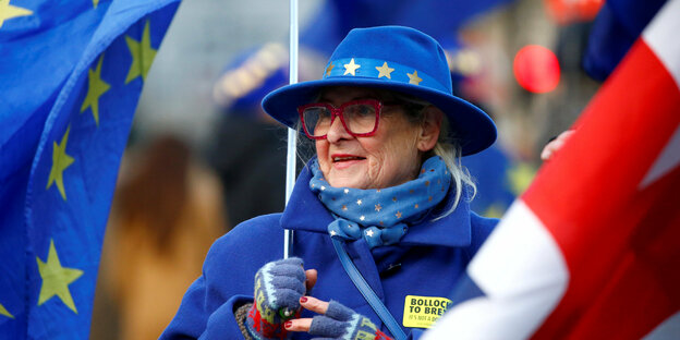 Frau mit Fahne, Hut und Jacke in blau mit Sternen (Europa-Fahne)