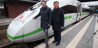 Vor einem Zug mit grünem Streifen stehen der Bundesverkehrsminister Scheuer (CSU) und der Bahnchef Lutz