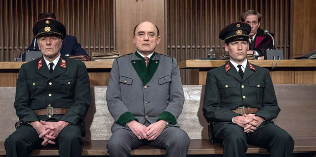 Drei Männer in Uniform sitzen auf einer Bank