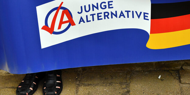 Sandalen hinter einer Banderole der AfD-Jugendorganisation