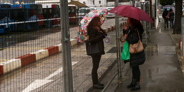 Zwei Frauen unterhalten sich auf Gibraltar durche einen Zaun hindurch
