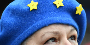 Eine Frau mit blauer Mütze mit gelben Sternen guckt nach oben