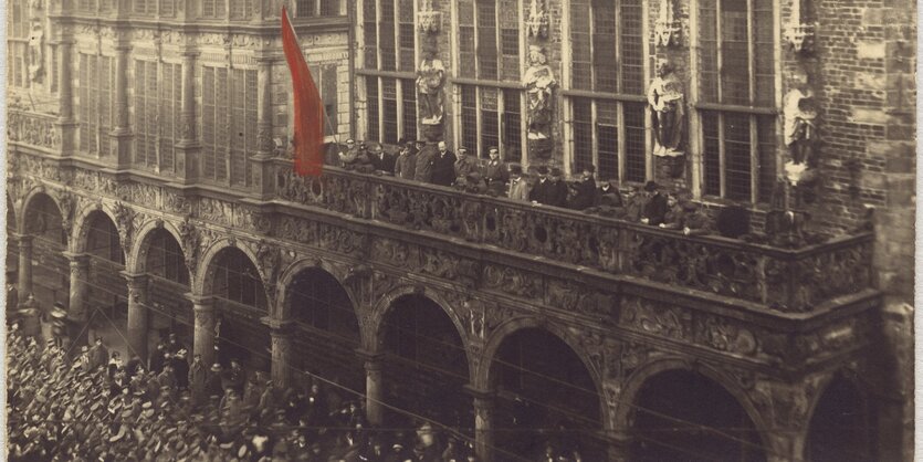 Eine rote Flagge prangt am Bremer Rathaus. Es ist eine historische Fotografie von der Novemberrevolution 1918