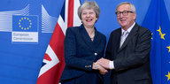 Theresa May und Jean-Claude Juncker reichen sich die Hände und lächeln dabei