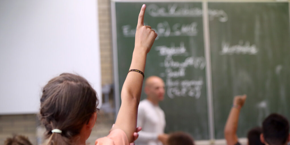 Ein Mädchen meldet sich im Schulunterricht