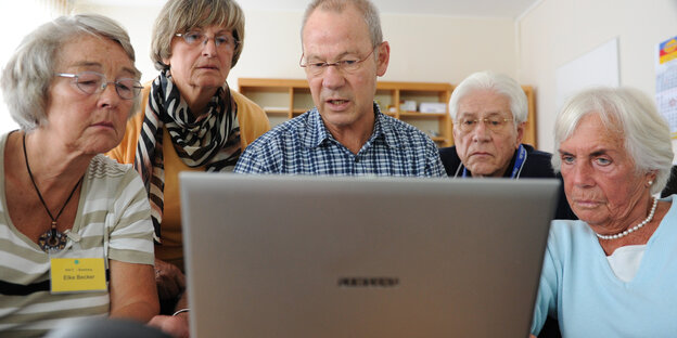 Fünf ältere Menschen blicken auf einen Computerbildschirm