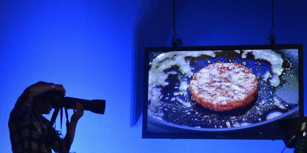 Ein Fotograf vor einem Bildschirm mit brutzelndem Fleisch