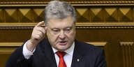 Petro Poroschenko steht am Rednerpult des ukrainischen Parlaments und hat den Finger in der Luft.
