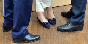 Die Füße von zwei Männern und einer Frau.