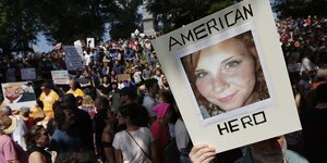 Ein Foto von Heather Heyer mit der Beschriftung „American hero“ wir bei einer Demonstration in die Höhe gehalten