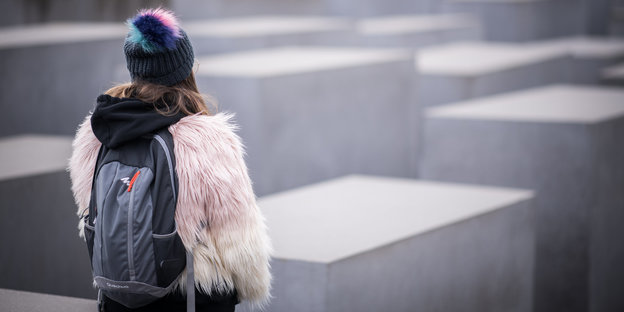 Am Holocaust-Denkmal in Berlin steht eine Frau
