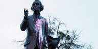 Eine mit einer pinken Farbbombe beworfene Statue von Immanuel Kant