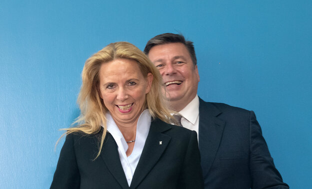 Eine Frau und ein mann stehen vor einen blauen Wand