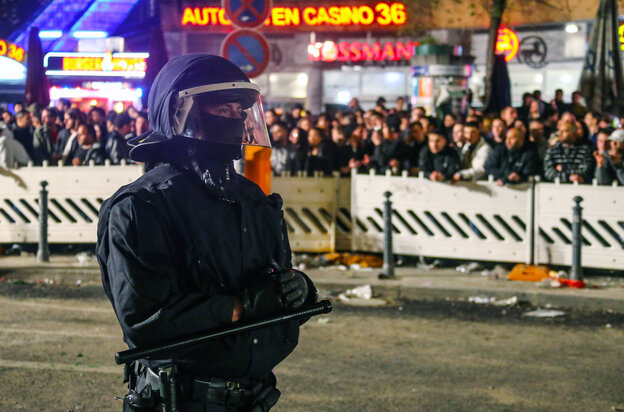 Ein Polizist in voller Montour steht vor einer gruppe von menschen