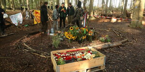AktivistInnen räumen Blumen und Kerzen für den im Hambacher Wald abgestürzten Journalisten Steffen Meyn in eine Kiste