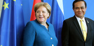 Angela Merkel steht neben Prayut Chan-o-cha. Beide lächeln
