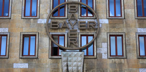 Ein Logo hängt an einem Gebäude des Bayer Konzerns