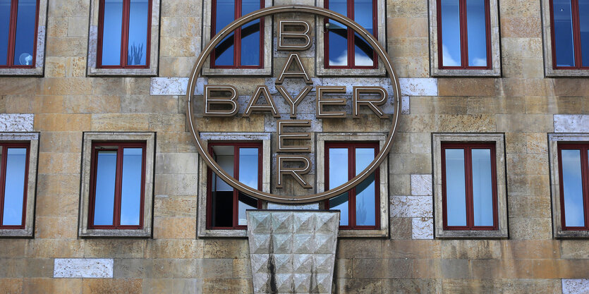 Ein Logo hängt an einem Gebäude des Bayer Konzerns