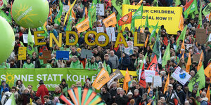 Demonstranten halten die Buchstaben "End Coal" nach oben, zudem werden zahlreiche Fahnen geschwenkt
