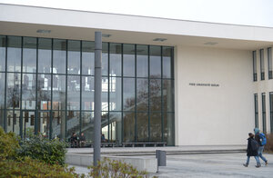 zwei Menschen stehen vor einem weißen Gebäude der FU zwei Menschen stehen vor einem weißen Gebäude der FU