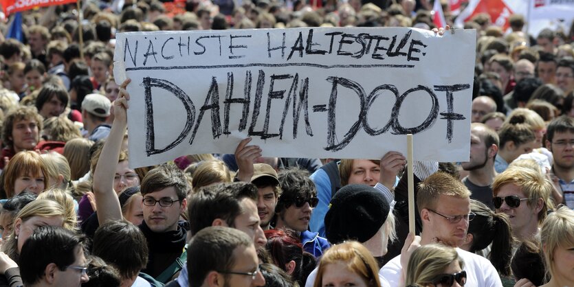 Menschen im Pulk tragen ein Plakat