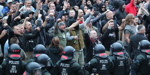 Polizisten stehen vor rechten Demonstranten