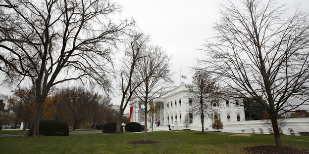 hinter großen Bäumen steht das Weiße Haus, der Regierungssitz des US-Präsidenten