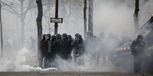 Polizisten stehen in einer Tränengaswolke