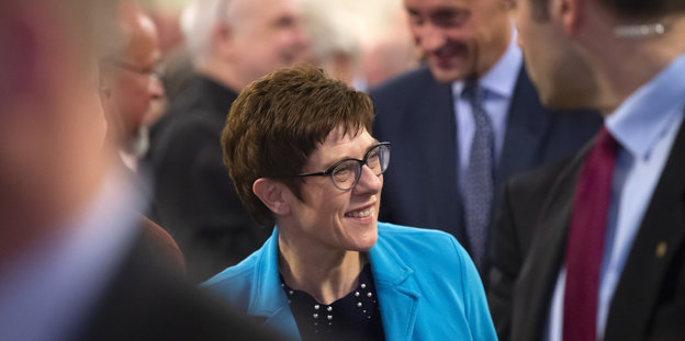 Die Kandidatin für den CDU-Vorsitz Annegret Kramp-Karrenbauer steht zwischen Männern in Anzügen