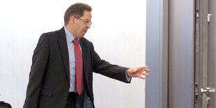 Hans-Georg Maaßen greift nach einem Türknauf