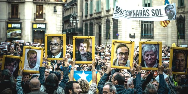 Demonstranten halten Fotos von gefangenen katalonischen Ex-Ministern hoch